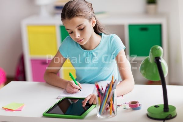 girl with tablet pc writing to notebook at home puwmfk2