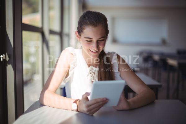 schoolgirl using digital tablet in classroom 8nlyd32