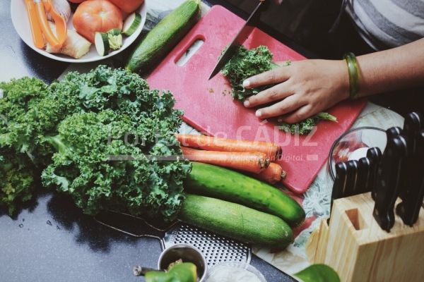 preparation for vegetarian dish using kale zucchini carrot in progress woman cutting all veggies to t20 8bjl1g