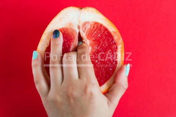 two fingers in a grapefruit isolated on a red background top view art attractive beauty bed clitoris t20 0xwv4b