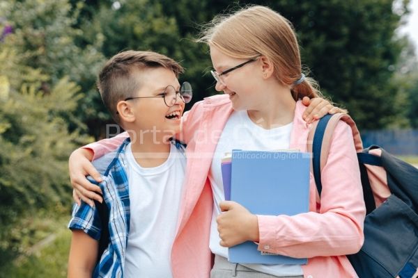 school children hugging after corona virus and flu outbreak boy and girl going back to school after t20 xgob6m