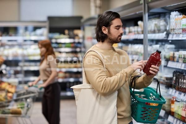 bearded young man shopping in supermarket and read 2023 11 27 05 21 36 utc