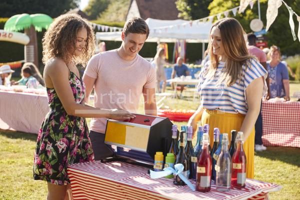 couple at tombola stall at busy summer garden fete 2021 08 26 16 15 16 utc