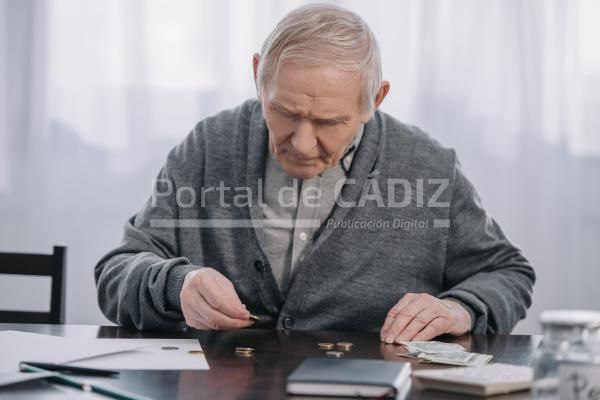 senior man sitting at table and counting money at 2023 11 27 04 49 51 utc